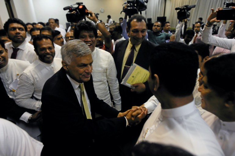Sri Lankan Prime Minister Wickremesinghe shakes hands with his party members who supported him after he survived a no confidence vote in the parliament in Colombo
