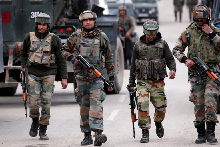 Indian army soldiers patrol a street near a site of a gunbattle between Indian security forces and suspected militants in Khudwani village of South Kashmir''s Kulgam district