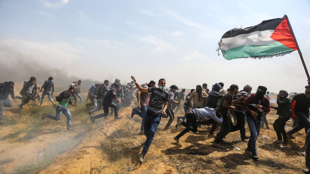 Palestinian protesters run from tear gas launched by Israeli forces [Mustafa Hassona/Anadolu Agency]