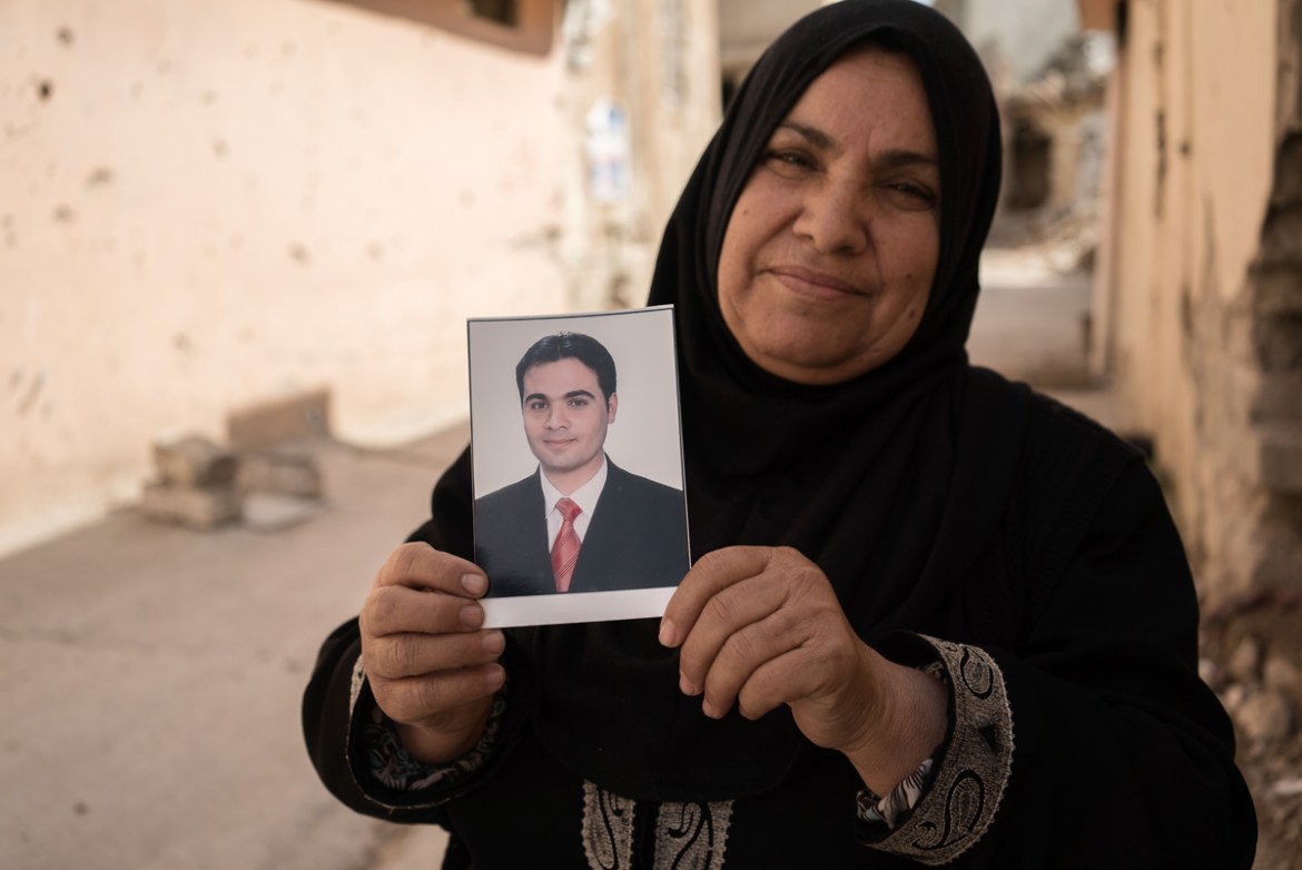 Fatimah, 43 shows the photo of her son. When she had the chance, Fatimah fled and spent 8 months in a camp. During that time, she heard stories about her son, Abdulhamad. Some say he was killed during