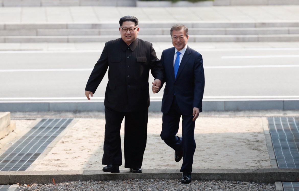 North Korean leader Kim Jong Un, left, and South Korean President Moon Jae-in, right, cross the military demarcation line to the South side at the border village of Panmunjom in the Demilitarized Zone