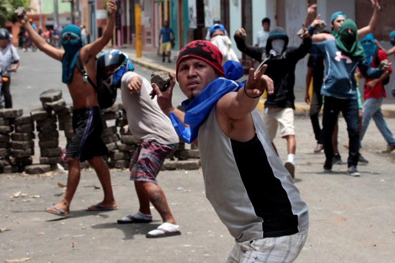 Demonstrators throw rocks towards riot police during protest against Nicaraguan President Daniel Ortega''s government in Monimbo