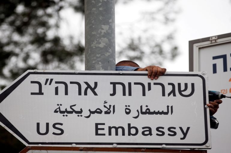 A worker hangs a road sign directing to the U.S. embassy, in the area of the U.S. consulate in Jerusalem, May 7, 2018. [Ronen Zvulun/Reuters]