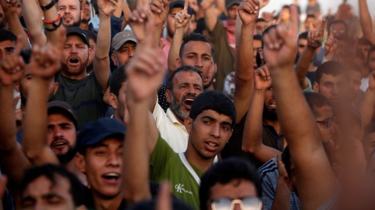 Palestinian demonstrators chant slogans during a protest demanding the right to return to their homeland, at the Israel-Gaza border, east of Gaza City