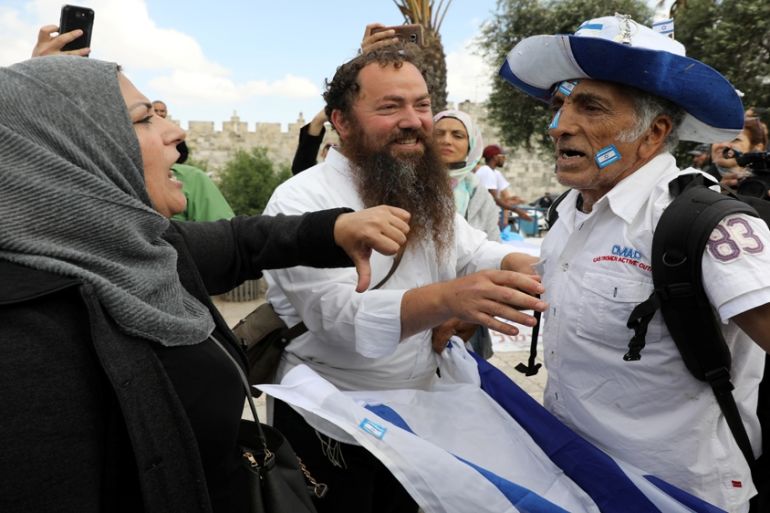 An Israeli man holds an Israeli flag as he argues with a Palestinian woman ahead of the annual Jerusalem Day parade outside Jerusalem''s Old City''s Damascus Gate, May 13, 2018. [Ammar Awad/Reuters]