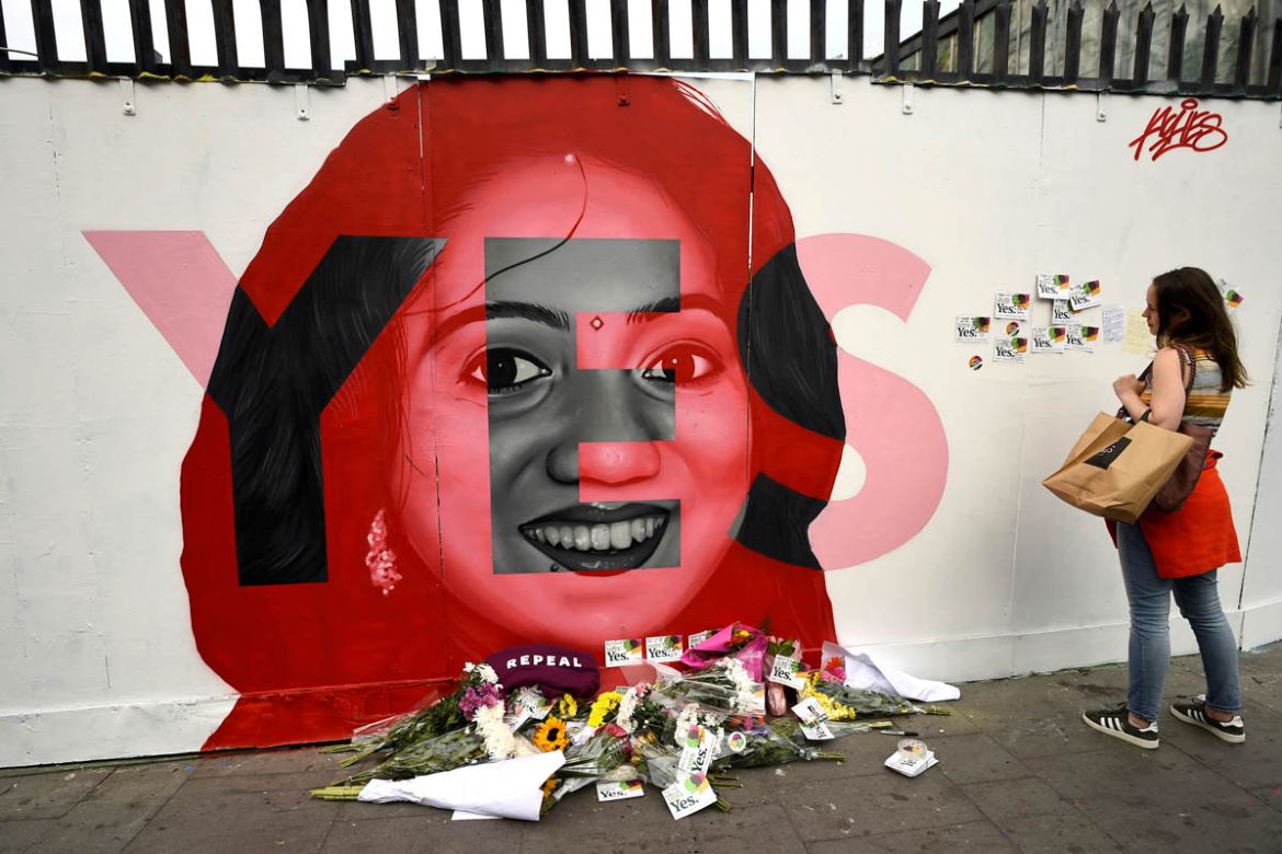 A woman looks at a new mural of Savita Halappanavar with flowers placed beneath it put up on the day of the Abortion Referendum on liberalising abortion laws in Dublin, Ireland May 25, 2018. REUTERS/C
