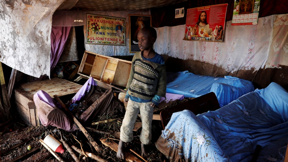 A child walks in his house, which was partly destroyed by flooding water in Solio town [Thomas Mukoya/Reuters]