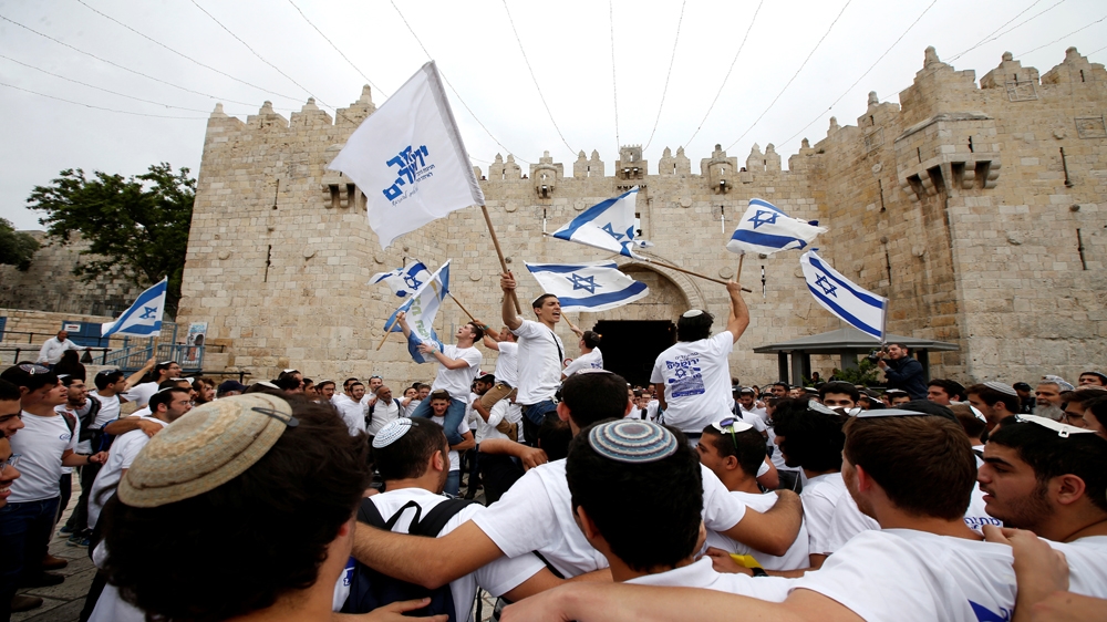 Marchers wave Israeli flags at Damascus Gate in Jerusalem's Old City [Baz Ratner/Reuters] 