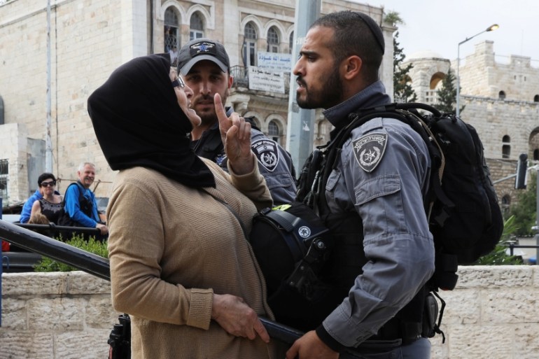 An Israeli police officer argues with a Palestinian woman outside Jerusalem''s Old City''s Damascus Gate, May 13, 2018. [Ammar Awad/Reuters]