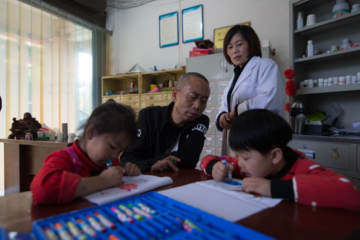 On this photo taken on May 10.2018, Zhao Xinghua and his wife Chen Jinlian watches their daughter Zhao Youwen and son Zhao Youcheng drawing on table. Zhao said he is generally easy with his children b