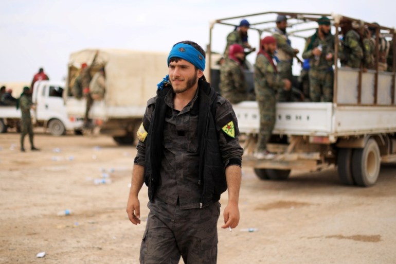 A fighter of Syrian Democratic Forces (SDF) walks in Deir al-Zor