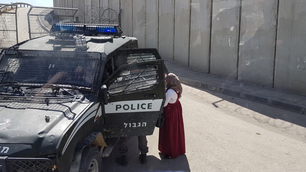 A young Palestinian mother was made to stand in the sun with her baby while officials at the checkpoint sat in their vehicle and questioned her. [Showkat Shafi/Al Jazeera]