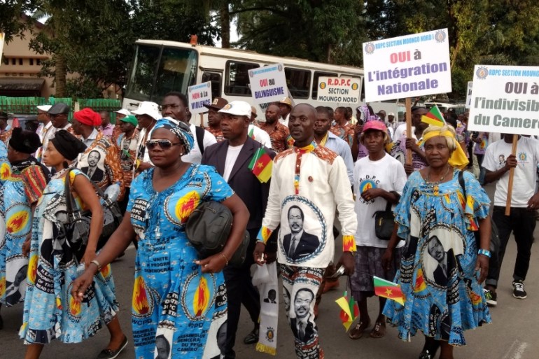 Demonstrators carry banners as they take part in a march voicing their opposition to independence or more autonomy for the Anglophone regions, in Douala