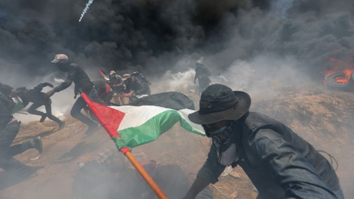 Palestinian demonstrators run for cover from Israeli fire a