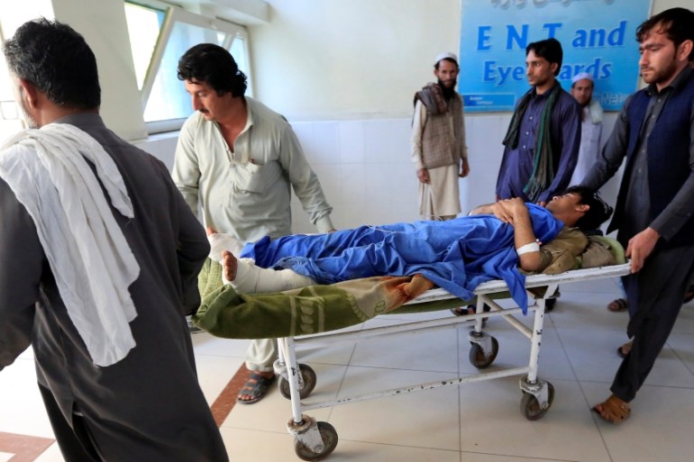 An injured man is transported on a stretcher in a hospital, after blasts at a sports stadium, in Jalalabad city, Afghanistan