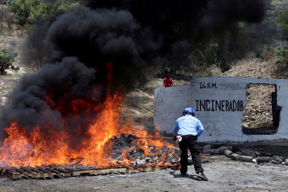 A member of the Attorney General''s Office (PGJ) is seen at the area where marijuana, packets of cocaine and other drugs seized during the current administration, are being incinerated, at a camp of th