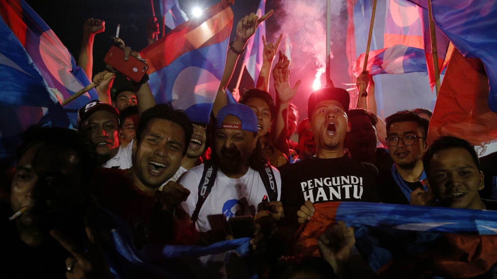 Supporters of Mahathir celebrate his shock victory [Athit Perawongmetha/Reuters]