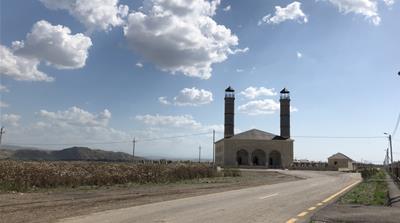 A newly built mosque in Jojug Marjanli; mountains in Iran can be seen to the left [Shafik Mandhai/Al Jazeera]