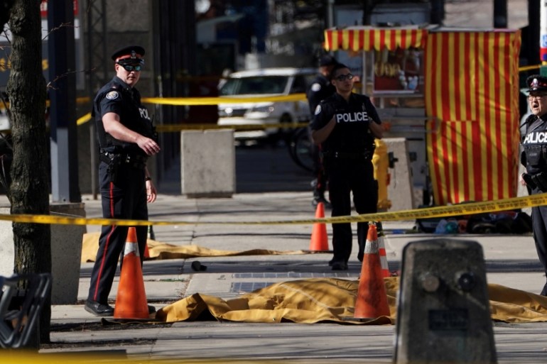 Police officers stand near covered bodies after a van struck multiple people at a major intersection in north Toronto [Source: Mediawires] REUTERS/Carlo Allegri