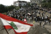 A Lebanese flag is seen as mourners bury 29 Lebanese victims - mostly women and children - of an Israeli attack in the Lebanese village of Qana, on August 18, 2006 [AP Photo/Lefteris Pitarakis]