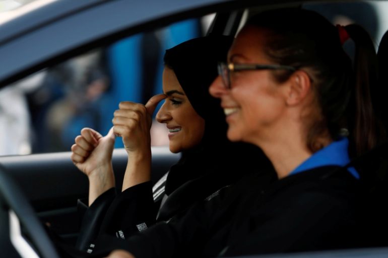 Saudi woman gestures as she sits in a car during a driving training at a university in Jeddah