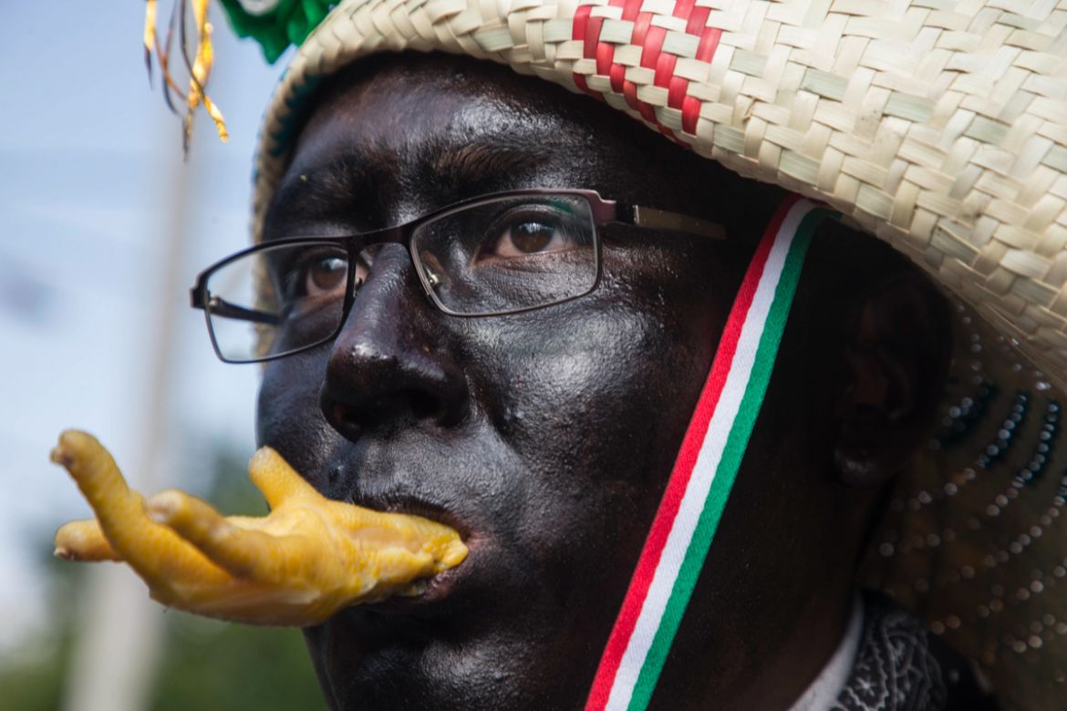 A man dressed as a revolutionary Zacapoaztla indigenous soldier eating a chicken leg marches during a re-enactment of The Battle of Puebla between the Zacapoaztlas and French army as part of the Cinco
