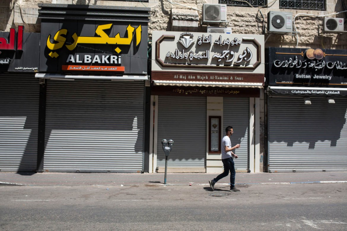 A young man passes in front of closed shops in Ramallah. est bank, to commemorate the 70th anniversary of the Nakba, and protest the killings that took place in the Gaza Strip the day before.