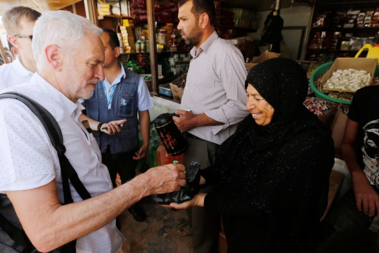 A Syrian refugee woman offers sweets to Britain''s opposition leader Jeremy Corbyn during his visit to Al Zaatari refugee camp, in the Jordanian city of Mafraq