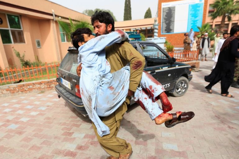 An injured man is carried to a hospital after a car bomb in Jalalabad city, Afghanistan