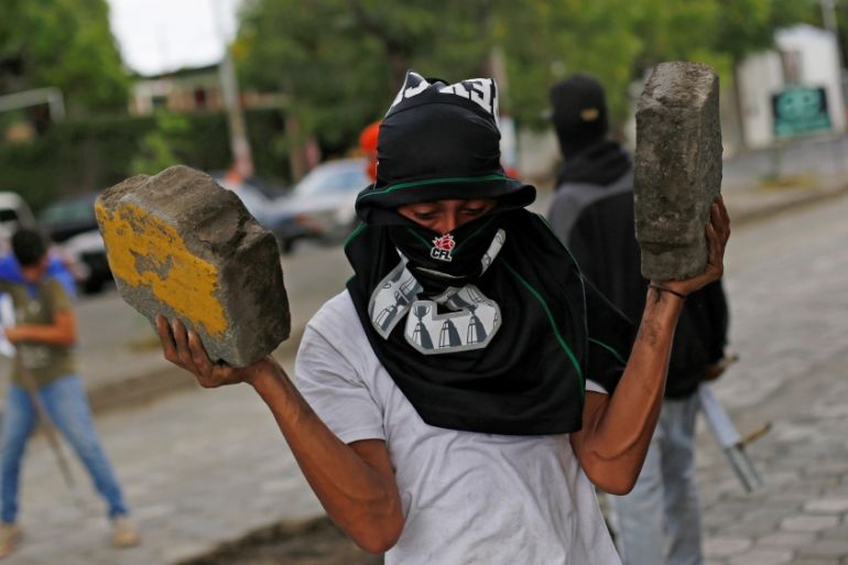 A demonstrator carries concrete blocks next to a barricade prior to a demonstration against Nicaraguan President Daniel Ortega''s government in Managua