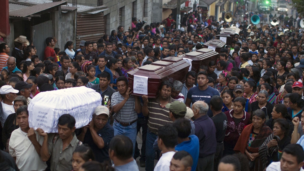 People carry to the cemetery the coffins of seven people who died during the eruption of the Volcan de Fuego [Luis Soto/AP]