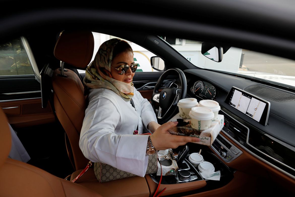 Samira al-Ghamdi, a practicing psychologist, gets coffee while driving her car to work, in Jeddah, Saudi Arabia June 24, 2018. REUTERS/Zohra Bensemra
