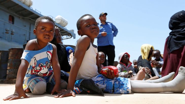 Migrants sit at a naval base after being rescued by Libyan coast guards in Tripoli