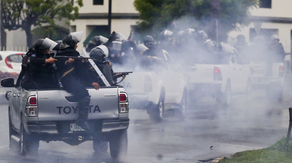 Police in riot gear riding on the back of pick-up trucks fire their shotguns towards university students taking part in a protest against Nicaragua's President Daniel Ortega in Managua. [Esteban Felix/AP Photo]