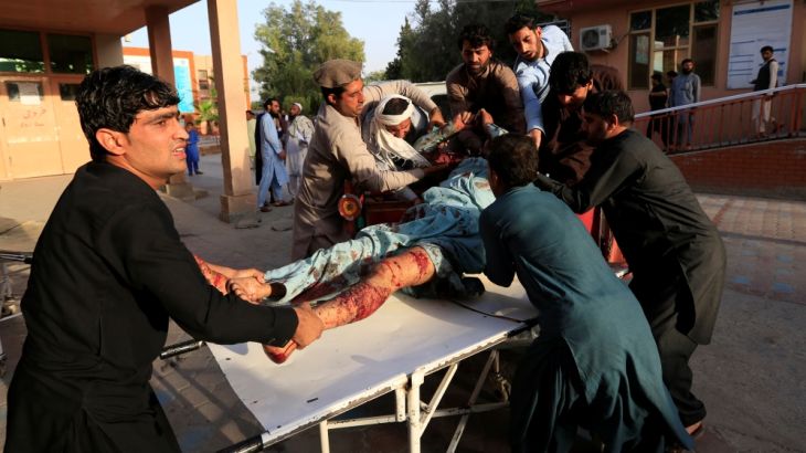 Men carry an injured man in a hospital after a car bomb, in Jalalabad city