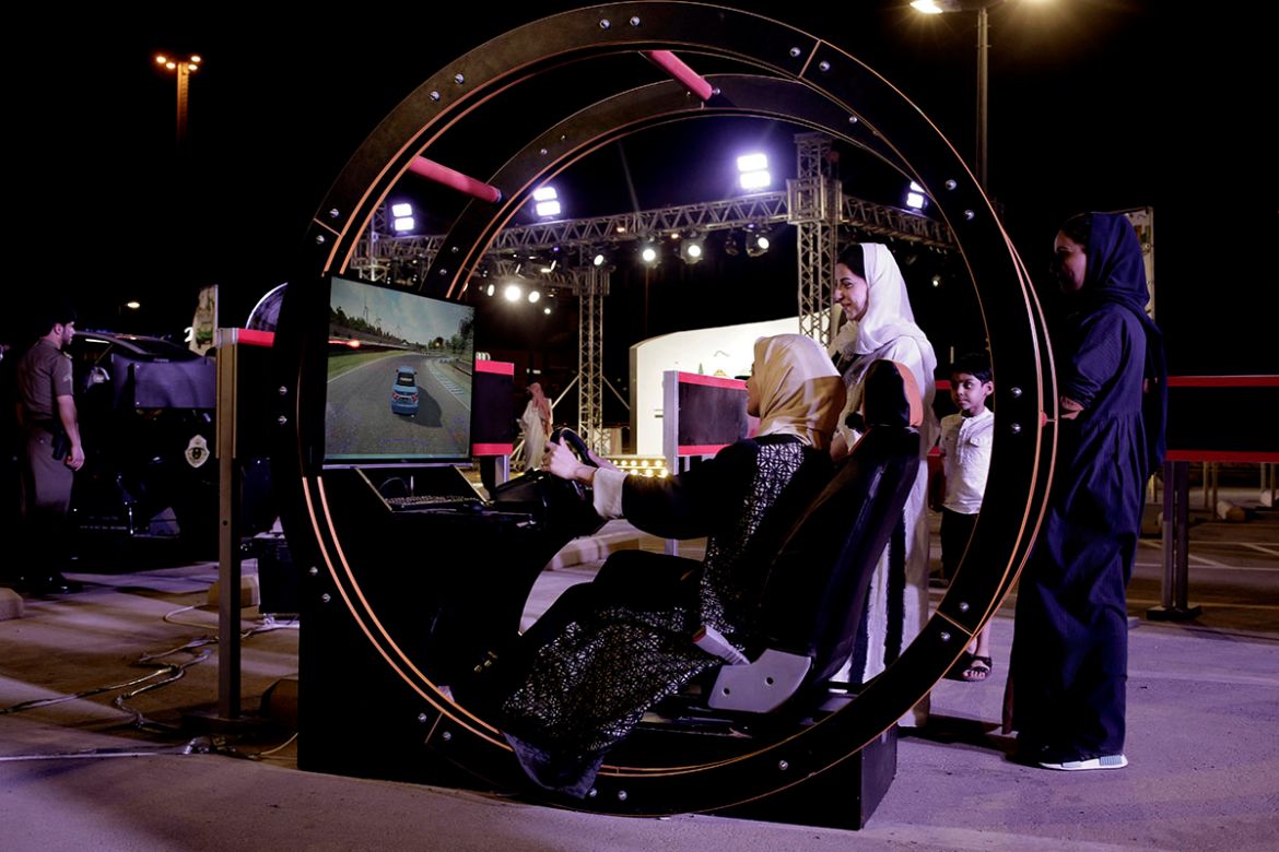 In this June 22, 2018 photo, a woman tests a car driving simulator at a road safety event for female drivers launched at the Riyadh Park Mall in Saudi Arabia. (AP Photo/Nariman El-Mofty)