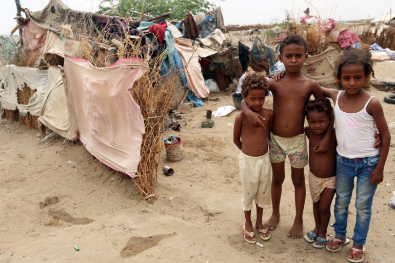 Children pose for a photo outside their family''s hut at a shantytown near the port of Hodeidah, Yemen