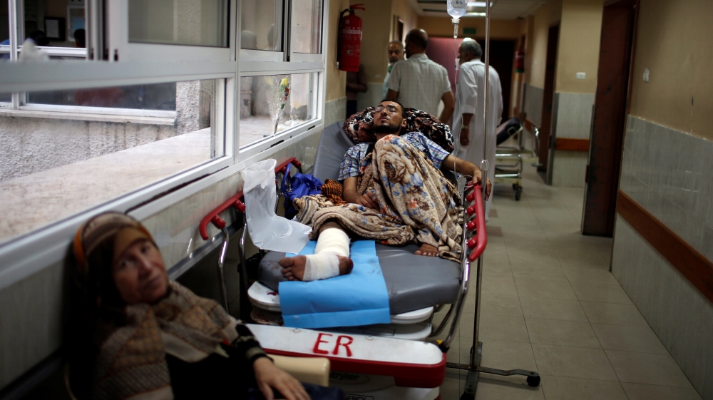 An injured Palestinian lies on a bed in the corridor of a hospital in Gaza City on May 15 [Mohammed Salem/Reuters]
