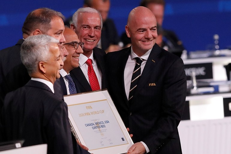 FIFA President Gianni Infantino (R) poses for a picture with officials after the announcement, that the 2026 FIFA World Cup will be held in the United States, Mexico and Canada, during the 68th FIFA C