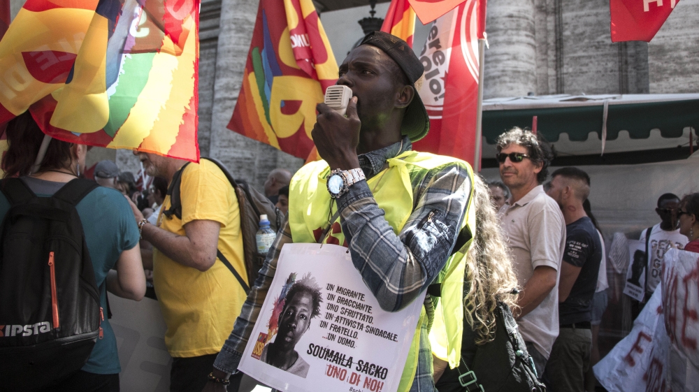 A demonstrator wears a placard in memory of Soumaila Sacko at a march in Rome on June 16 [Ylenia Gostoli/Al Jazeera]