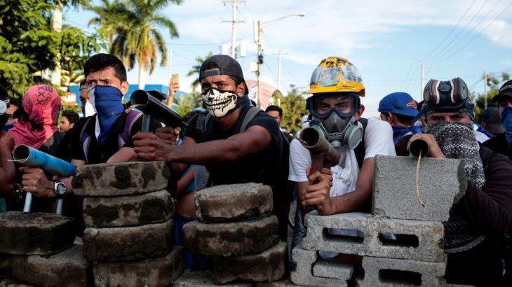 Demonstrators stand behind a barricade during clashes with riot police during a protest against Nicaragua''s President Daniel Ortega''s government in Managua, Nicaragua. [Oswaldo Rivas/Reuters]