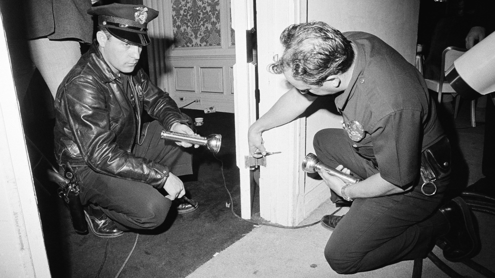 Charles Wright, a police technician, and officer Robert Rozzi inspect a bullet hole found in a doorframe in a kitchen corridor of the Ambassador Hotel in Los Angeles near where Robert F Kennedy was shot. The bullet was still in the wood [File photo: Dick Strobel/AP]