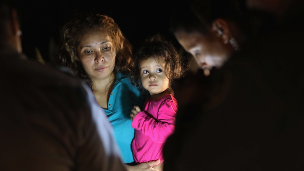 A Honduran girl and her mother are taken into custody near the US-Mexico border on June 12 [John Moore/AFP]