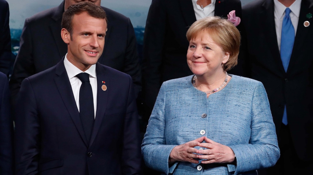 France's Emmanuel Macron and Germany's Angela Merkel in La Malbaie [Yves Herman/Reuters]
