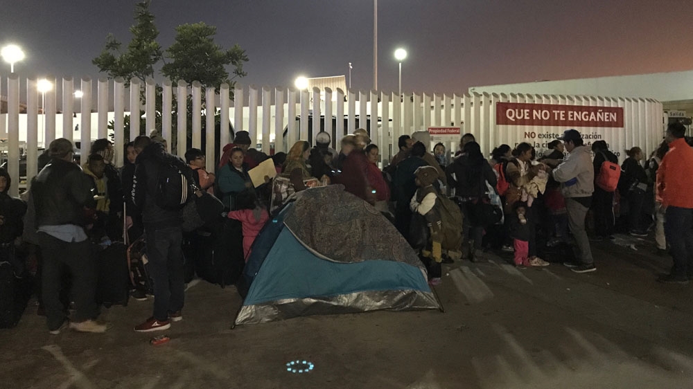 Refugees and migrants wait at the El Chaparral border crossing in Tijuana, hoping to enter the US [Walker Dawson/Al Jazeera]