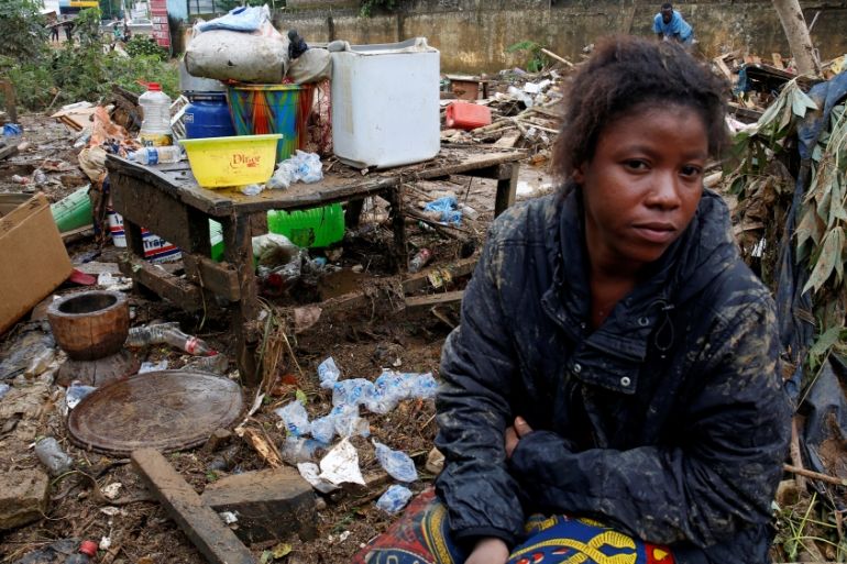 A woman sits between her belongings and the debris after flood in Abidjan