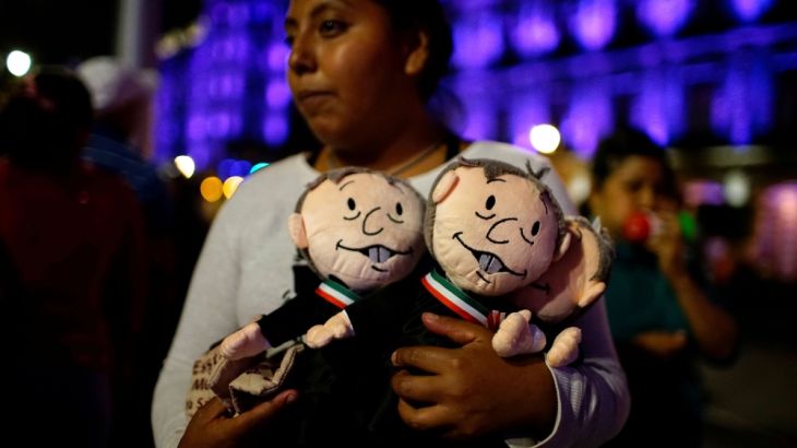 A supporter of presidential candidate Andres Manuel Lopez Obrador holds dolls depicting him as she waits for the presidential election results in downtown Mexico City, Mexico July 1, 2018. REUTERS/Ale