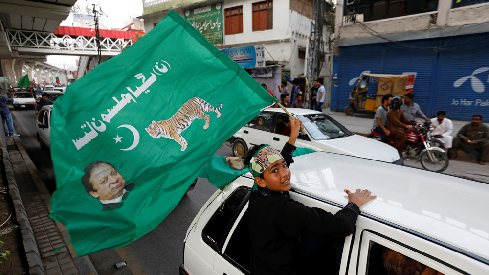 A supporter of Pakistan Muslim League-Nawaz (PML-N) waves a party flag in Rawalpindi [Faisal Mahmood/Reuters]