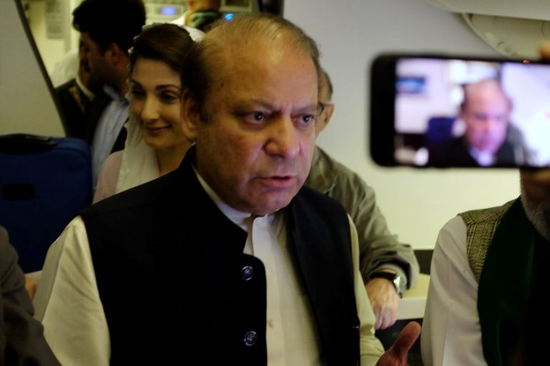 Ousted Pakistani Prime Minister Nawaz Sharif gestures as he boards a Lahore-bound flight due for departure, at Abu Dhabi International Airport