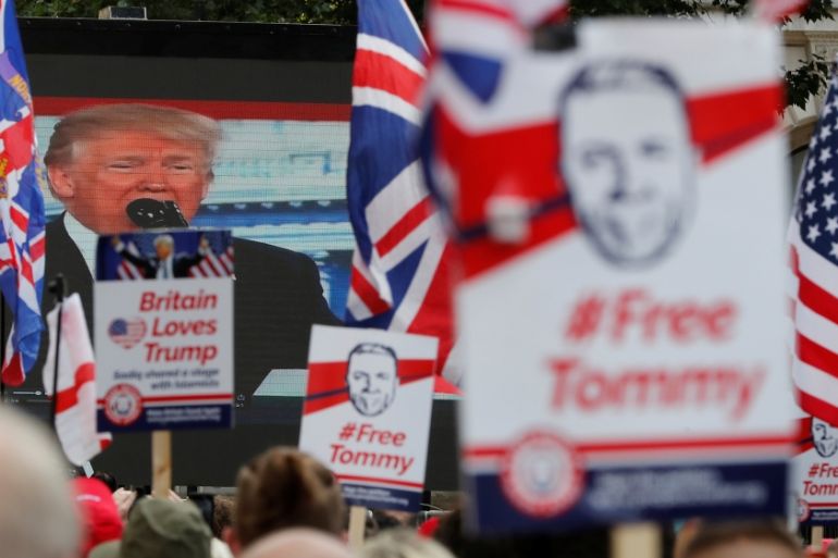 Demonstrators hold placards supporting EDL founder Tommy Robinson and U.S. President Donald Trump in London